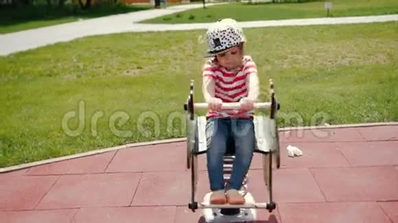 小女孩在公园里玩坐在秋千上视频的预览图