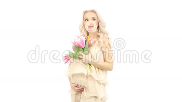 穿着粉红色裙子的孕妇捧着一束郁金香飞来飞去吹着泡泡白色的视频的预览图