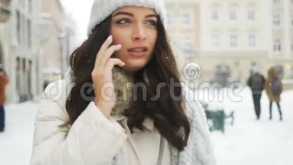 快乐的女孩在电话里交谈城市白雪冬天的圣诞节视频的预览图