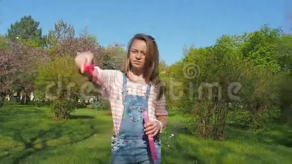 公园里有肥皂泡的十几岁女孩女孩在阳光明媚的日子里呼吸新鲜空气一个孩子在大自然中玩泡泡视频的预览图