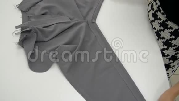 女性的双手展开灰色的织物来显示裤子上的接缝视频的预览图