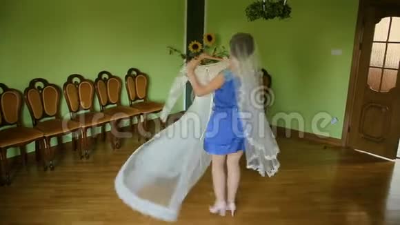 年轻漂亮的女人选择婚纱摆姿势和尝试视频的预览图