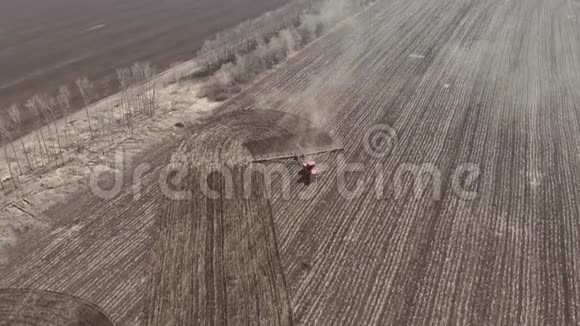 4空中镜头现代红色拖拉机在农业领域在阳光明媚的日子拖拉机耕地拖拉机培育视频的预览图