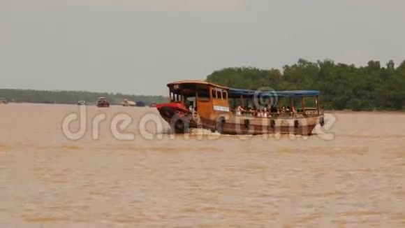 游客乘坐机动木船沿着湄公河航行视频的预览图