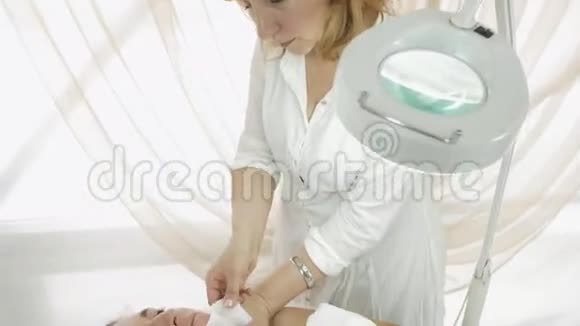 专业美容师在美容院做打蜡女孩下巴中型射击视频的预览图