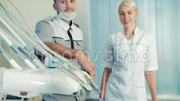 牙医和他的助手站在特别的椅子上靠近快乐的病人视频的预览图