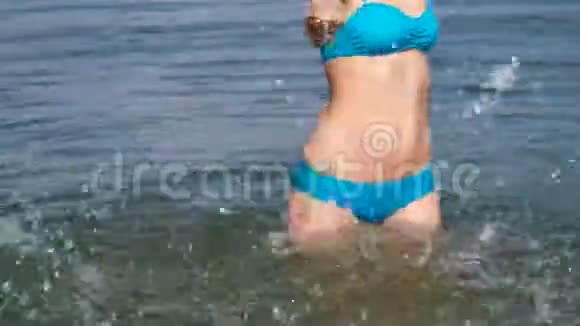 美丽的女孩在海里溅水视频的预览图
