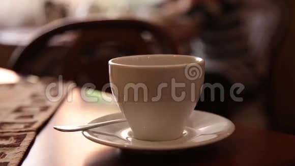 年轻漂亮的女人坐在咖啡馆喝茶或咖啡微笑着视频的预览图