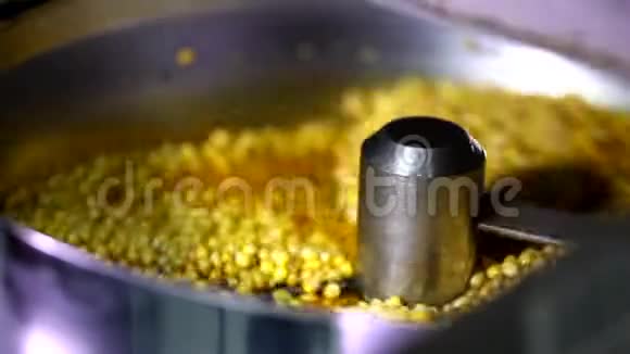 将小玉米种子与焦糖甜酱混合开盖的自动旋转爆米花机特写镜头视频的预览图