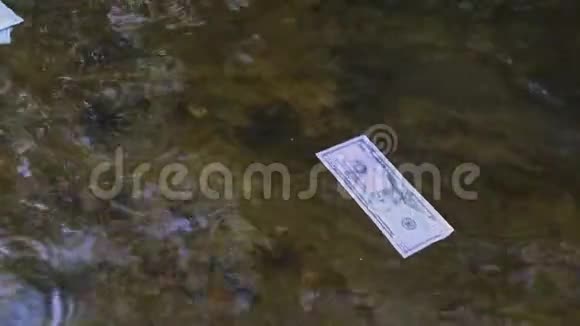 一张美元钞票沿着河漂关于意外财富主题的概念视频的预览图