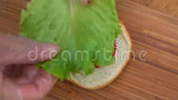 厨师把莴苣叶放在面包上视频的预览图
