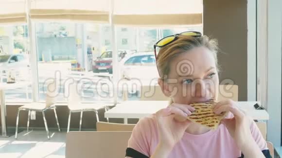 漂亮的女人吃三明治在快餐店喝咖啡快餐视频的预览图