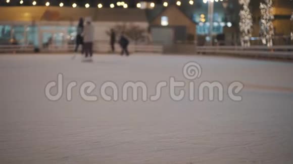 晚上一群面目全非的人骑在一个开放的冰场上冬季滑冰公众溜冰场视频的预览图
