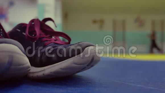 运动鞋在健身房的垫子上在后台跑步女孩热身模糊背景概念运动室内视频的预览图