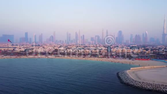 迪拜天际线从海岸或海滩与城市景观和摩天大楼与BurjKhalifa背景奇妙的空中飞行视频的预览图
