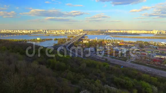摄像机飞越基辅市房屋屋顶街道Dnipro河桥梁视频的预览图