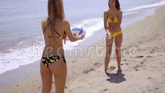 两个身材匀称的女人在玩沙滩球视频的预览图