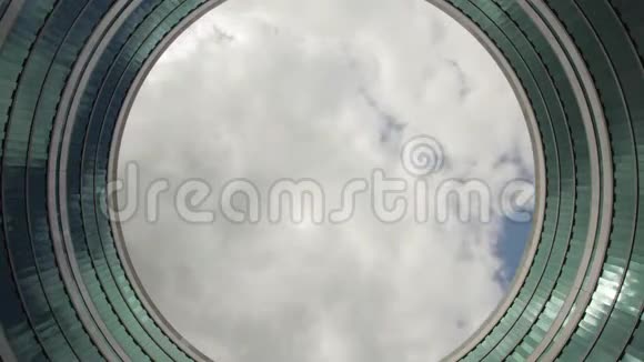 天空的时间流逝穿过一座圆形的环状建筑物视频的预览图