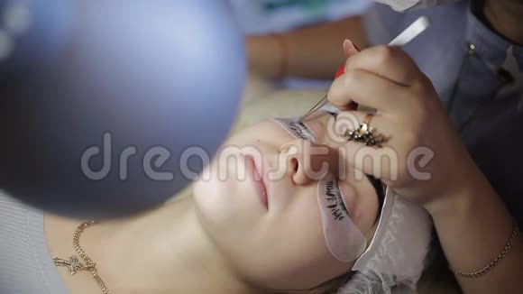 首席美容师在手术后使用雾化器睫毛扩展睫毛延长的程序视频的预览图
