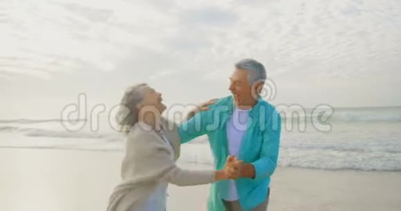 活跃的老夫妇一起在海滩上跳舞视频的预览图