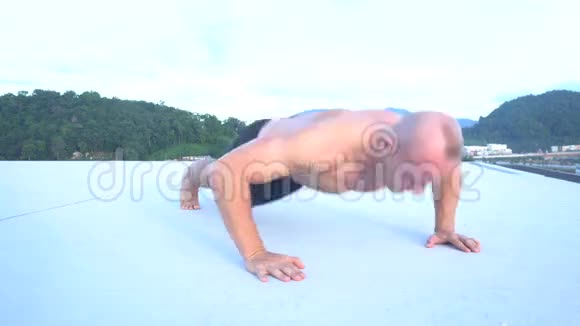 健身运动男子在屋顶外拍俯卧撑视频的预览图