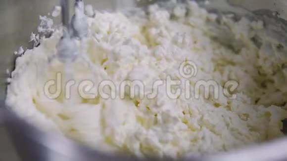 在搅拌机里搅拌奶油家庭主妇混合奶油做松饼近景视频的预览图