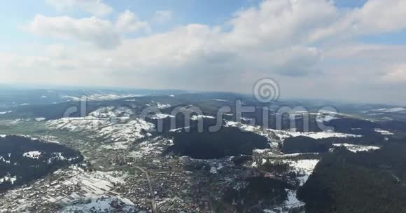 空中观景高过白雪皑皑的连绵山丘小镇视频的预览图