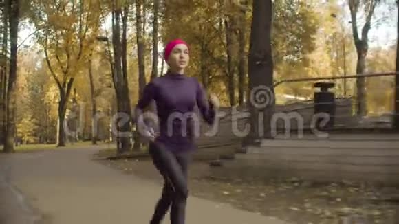年轻的女运动员沿着马路跑视频的预览图