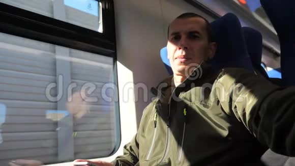 乘坐地铁列车的中年智能手机坐在窗口旁的一位不知名的旅行者给社交网站写短信视频的预览图