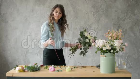 人生意销售和花艺的概念快乐微笑的花艺女人在花店做束花束与视频的预览图