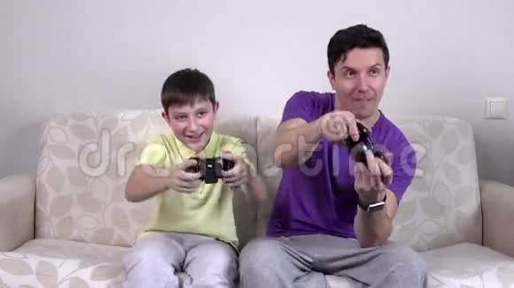 带着电子游戏控制器的男人和男孩微笑视频的预览图
