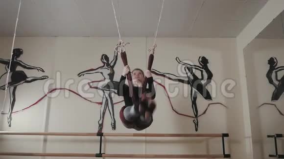 年轻女性在工作室里用吊床练习空中不同的反重力瑜伽精神和精神概念视频的预览图