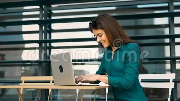 美丽的布鲁内特女孩用电脑工作视频的预览图