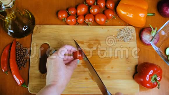 一个女人正在用菜刀切一个樱桃番茄视频的预览图