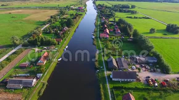 靠近河边的村庄阳光明媚的夏日无人机在河边的一个小村庄里拍摄视频的预览图