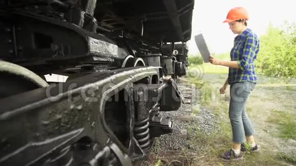 一个年轻的女火车司机检查货车的车轴箱视频的预览图
