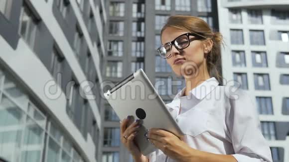 公司前面有平板电脑的女商人视频的预览图