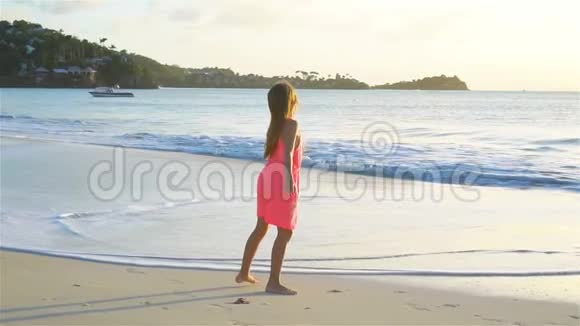 可爱的快乐小女孩在日落的白色海滩上玩得很开心流动电视视频的预览图