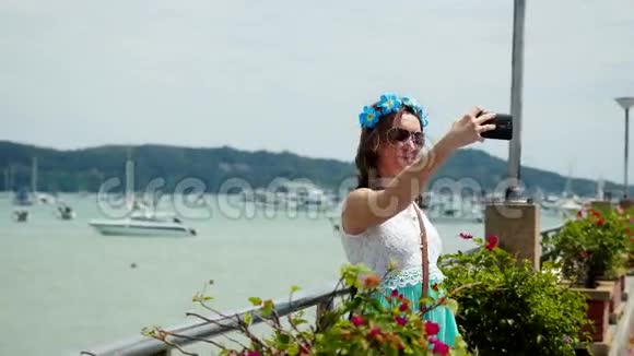 年轻漂亮的女人头发上有花在度假时拍自拍照片3840x2160视频的预览图