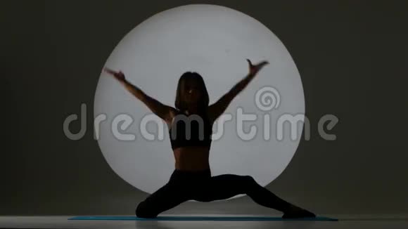 体操运动员做分裂和倾斜身体向前背光剪影视频的预览图