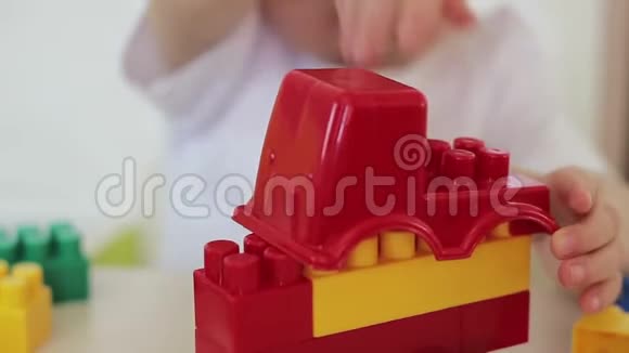桌子旁的孩子玩玩具车和彩色积木儿童发展视频的预览图