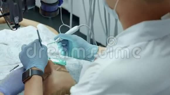 牙科医生在牙科办公室使用牙科显微镜操作一名女性病人视频的预览图