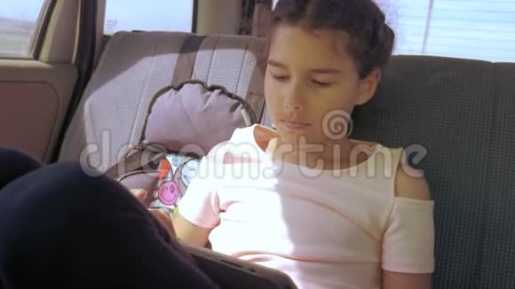 带着平板电脑的小女孩去美国德克萨斯旅行女孩汽车概念旅行交通生活方式视频的预览图