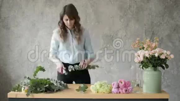 人生意销售和花艺的概念快乐微笑的花艺女人在花店做束花束与视频的预览图