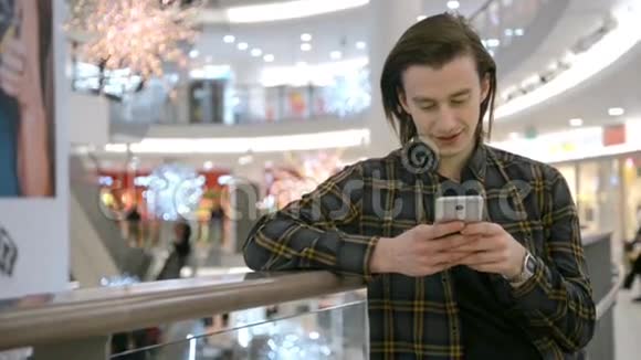 在城市的夜晚人们使用智能手机上的应用程序短信英俊的年轻商人用智能手机微笑快乐视频的预览图