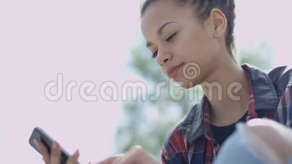非洲裔美国年轻女性在户外看手机的肖像视频的预览图