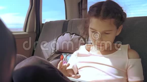 带着平板电脑的小女孩去美国德克萨斯旅行女孩的生活方式汽车概念旅游交通视频的预览图