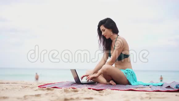 在海边有笔记本电脑的年轻女子视频的预览图