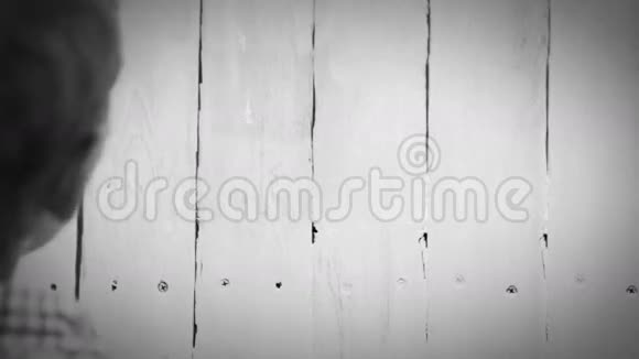 一个男孩用白色油漆栅栏的黑白加速镜头视频的预览图