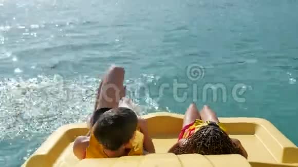 孩子们躺在游艇船海上休息儿童海上度假童年孩子们在海里坐双体船视频的预览图